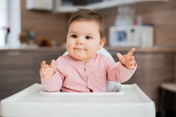 愛らしいです幼児女の子座っていますでA背の高い子供の椅子でザキッチン — ストック写真