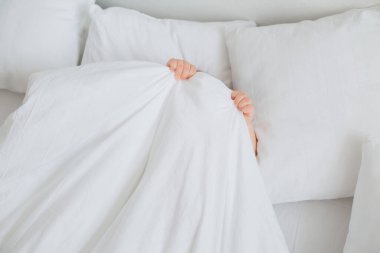 Sevimli, mutlu, küçük çocuk yatakta yatıyor. 