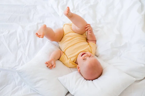 Foto Baby Gul Kroppsdräkt Som Ligger Kuddar Skarp Vit Säng — Stockfoto