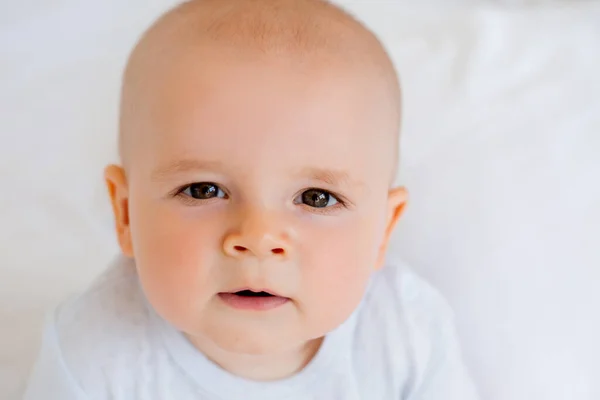 6ヶ月の明るい赤ん坊の男の子の写真でベッドの中の白いボディスーツ — ストック写真