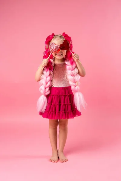 Маленькая Счастливая Девочка Большими Розовыми Косичками Веселится Леденцами Форме Сердца — стоковое фото