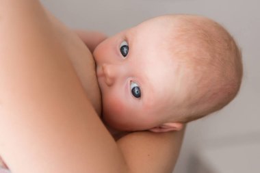 Anne yeni doğmuş bebeğini evde emzirirken.