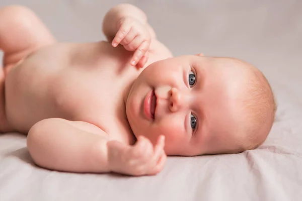 Ευτυχισμένο Μωρό Μηνών Που Χαμογελάει Ξαπλωμένο Στο Λευκό Κρεβάτι — Φωτογραφία Αρχείου