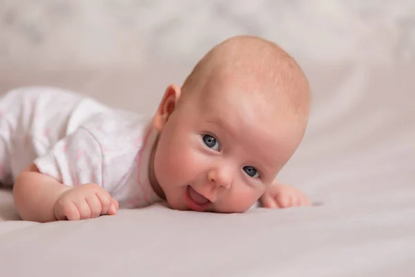 3个月大穿着白色紧身衣的健康女婴躺在床上 — 图库照片