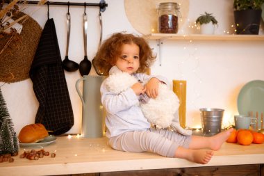 Mutfaktaki tatlı küçük kız oyuncağıyla evde. 