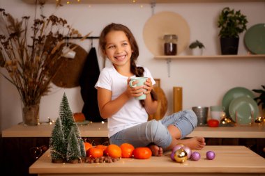 Mutfakta oturan fincanlı tatlı kız. 