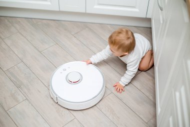 Küçük şirin bebek ve robot süpürge.