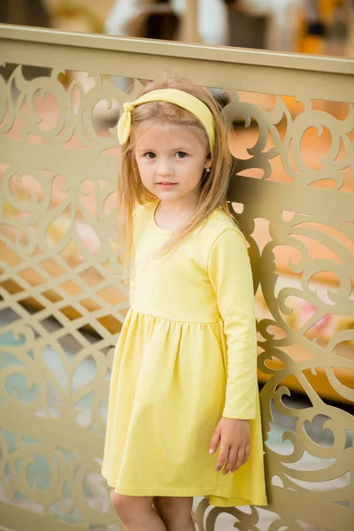 幸せなブロンド女の子で黄色のドレスで遊園地 — ストック写真