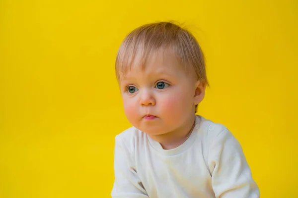 白いボディスーツの健康な赤ちゃんは黄色の背景に座っている テキストのためのスペース — ストック写真