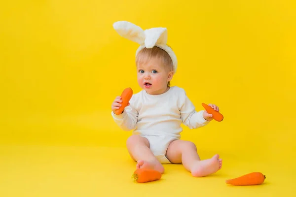 Ребенок Белом Купальнике Кроличьими Ушами Голове Ест Морковь Сидит Желтом — стоковое фото