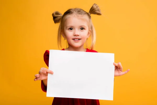 Sarı arka planda beyaz bir çarşaf tutan bir kızın fotoğrafı. Reklam metniniz için boşluk resmini yerleştirerek kopyalayın