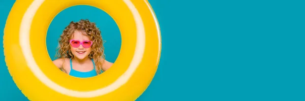 little girl playing with inflatable ring in the pool