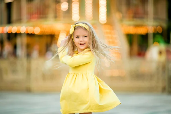 Happy Blond Little Girl Yellow Dress Amusement Park — Stock Photo, Image