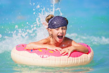 Daire üzerinde mutlu küçük kız. Denizde sıçramasına. Tatil kavramı.