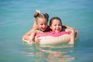 Mutlu kız denizde. Denizin üzerinde bir daire neşeli kız float