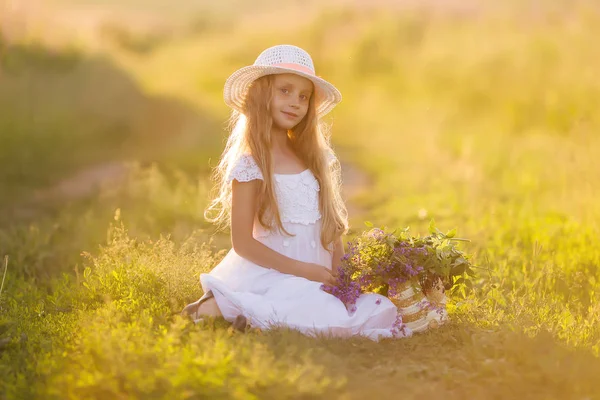 在田野日落的帽子里戴着长发的可爱少女的肖像 — 图库照片