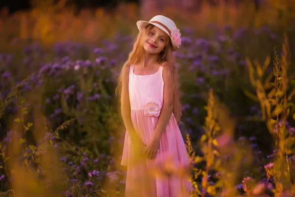 フィールドで日没時帽子の長い髪のかわいい少女の肖像画 — ストック写真