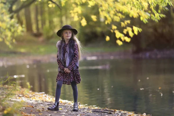 Güzel bir gülümseyen moda kızlar shlyape portresi. Uzun saç, beklemede su birikintisi güneşli bir kızla krasota