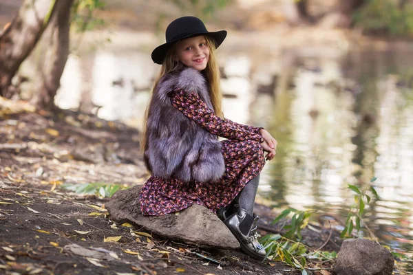 Gölet yakınındaki parkta yürüyüş şapkalı tatlı gülümseyen kız