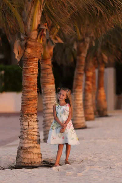 Sweet smiling girl near the palm trees on vacation