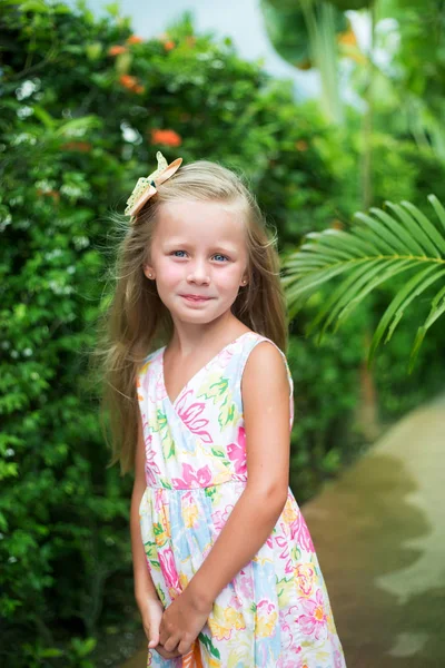 stock image Portrait of a smiling little girl. Girl on the background of greenery in the tropics.