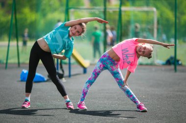 Kızlar stadyumda egzersiz yapıyorlar. Kızlar stadyumda fitness yapıyor.