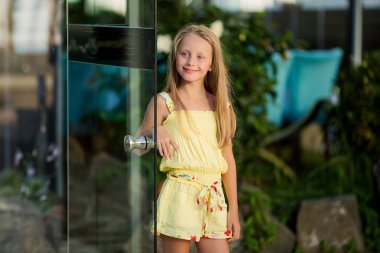 Uzun saçlı sevimli gülümseyen güzel kız. 8 yaşındaki bir kızın yaz portresi.