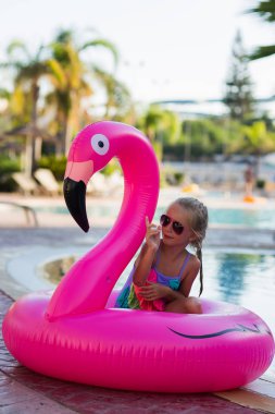 Havuzda flamingo daire sevimli kız. Yaz zamanı. Tatil.