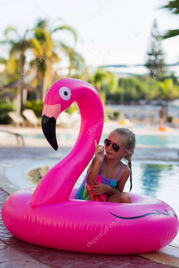 Cute girl in a flamingo circle in the pool. Summer time. holidays.