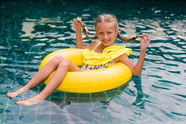 Yüzme havuzunda eğleniyor şişirilebilir kauçuk daire ile mutlu küçük kız