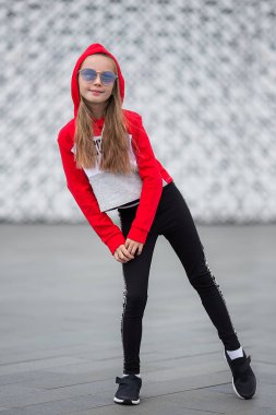 Eşofmanlı küçük kız sokakta modern dans ediyor. Genç şehirli hip hop dansçısı