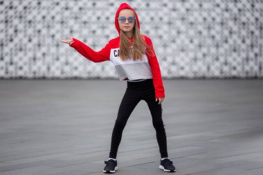 Dans için takım elbiseli kapüşonlu bir kızın portresi. Sokakta hip hop dansı yaptığı kız. Genç kentsel hip hop dansçısı