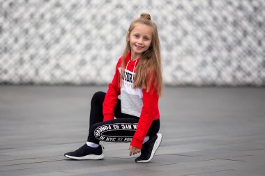 Eşofmanlı küçük kız sokakta modern dans ediyor. Genç şehirli hip hop dansçısı