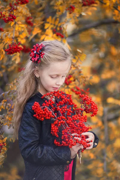 在秋天的森林里 一个秀丽的小女孩 卷曲着飘扬的头发 手里拿着一束玫瑰花 — 图库照片