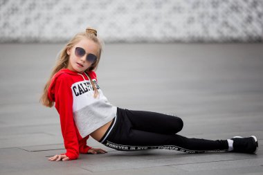 Eşofmanlı küçük kız sokakta modern dans ediyor. Genç şehirli hip hop dansçısı