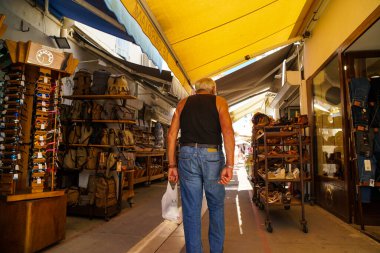 Saintes Maries de la Mer - 09 / 04 / 2020: sırtı yaşlı bir adam sokakta dükkanların arasında yürüyor