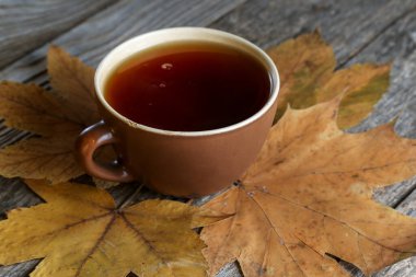 Eski ahşap bir masada bir fincan çay.