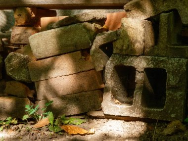 Bir yığın eski inşaat malzemesi benekli güneş ışığı altında.