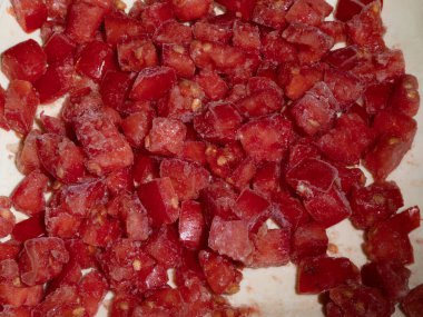 Buzla kaplı doğranmış kırmızı domatesler, yukarıdan yakın çekim..