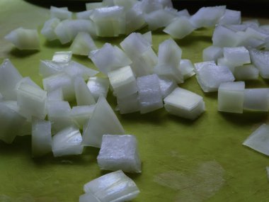 Yeşil bir tahtaya serpilmiş taze doğranmış soğan yakın plan..