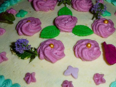 Güzel pembe gülleri olan şenlikli bir pastanın detaylı fotoğrafı..