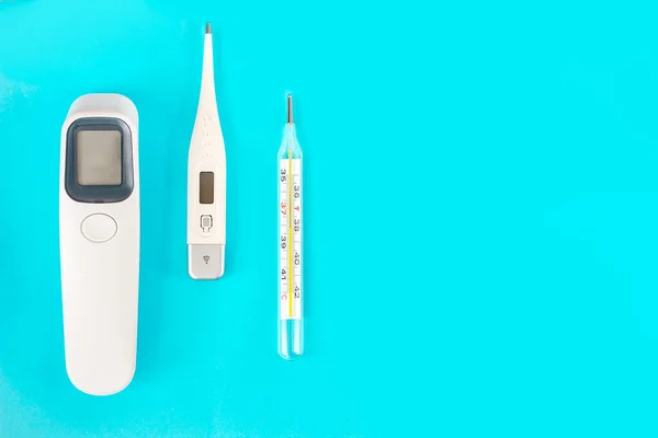 digital thermometer mercury and non-contact on a blue background, progress in medicine