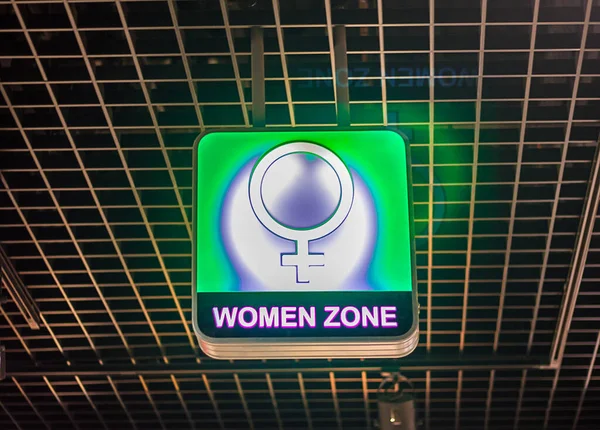 The concept of gender inequality, a female gender symbol on a luminous neon sign with the words \