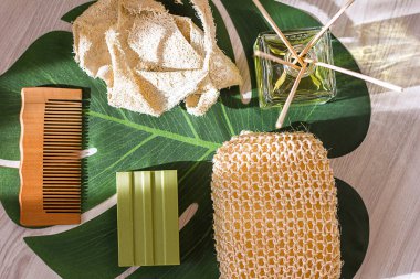 Doğal ekolojik bez, kuru masaj için ahşap fırça, zeytin sabunu ve ahşap tarak, ahşap ışıklı arka plan, üst görüş, ekoloji kavramı ve doğal ürünlerle vücut bakımı.