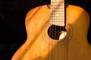 Güneş ışığıyla aydınlatılan ve gitar öğrenme romantizmi çalan altı telli klasik gitar.