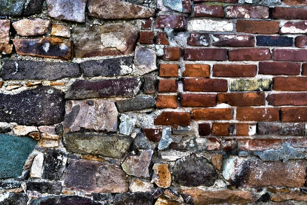 Old house wall of bricks, broken natural stones and old minerals, surrealistic texture background