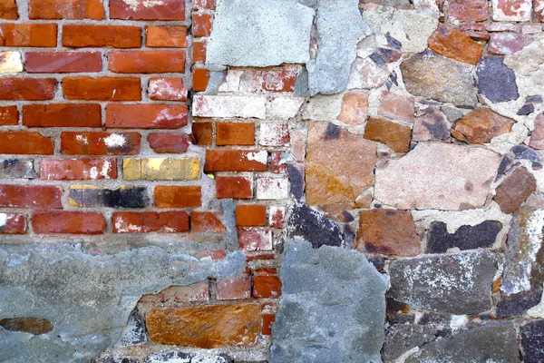 Old house wall of bricks, broken natural stones and old minerals, realistic texture background