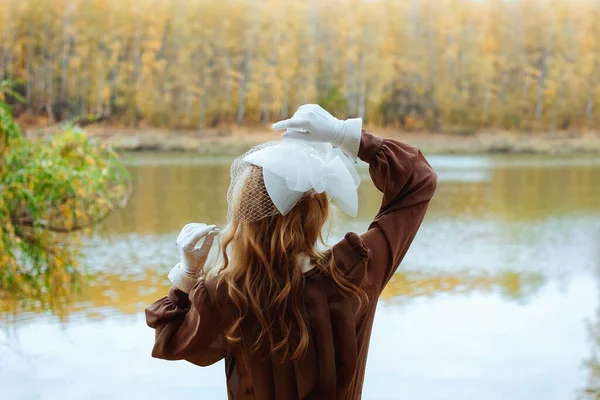 秋の公園の湖の近くのレトロなドレスの若い女性の肖像画 — ストック写真