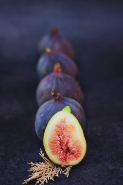 Masadaki koyu arkaplanda taze incir. Düz yatıyordu. Üst görünüm. 