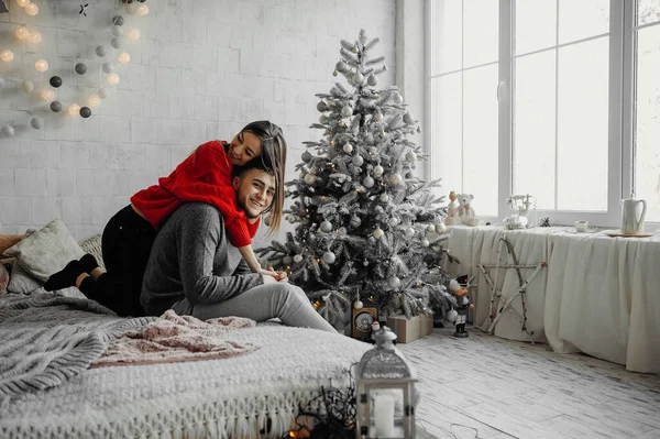 Feliz pareja amorosa disfrutando de la Navidad divirtiéndose juntos en la cama cómoda — Foto de Stock